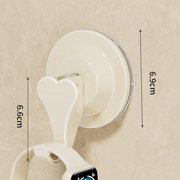 Heart-shaped suction hook with dimensions on a beige wall background